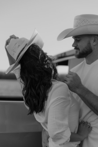 A couple in neutral attire in an open field in Fort Worth, Texas take their documentary style wedding engagement photos.