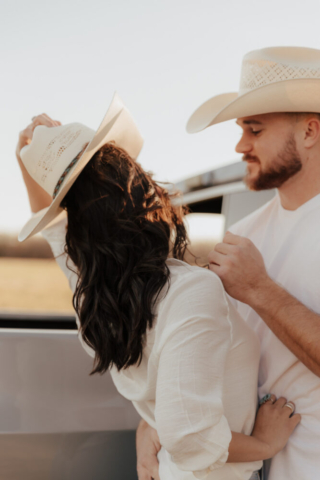 A couple in neutral attire in an open field in Fort Worth, Texas take their documentary style wedding engagement photos.