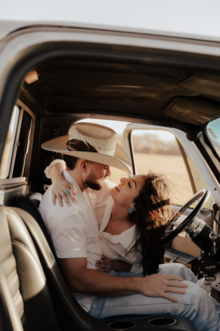 A couple in neutral attire in an open field in Fort Worth, Texas take their documentary style wedding engagement photos.