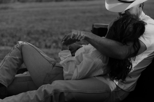 A couple in neutral attire in an open field in Fort Worth, Texas take their documentary style wedding engagement photos.