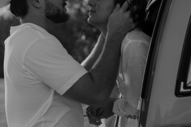 A couple in neutral attire in an open field in Fort Worth, Texas take their documentary style wedding engagement photos.