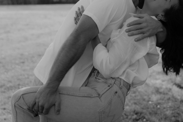 A couple in neutral attire in an open field in Fort Worth, Texas take their documentary style wedding engagement photos.