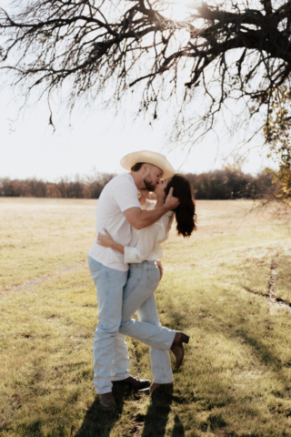 A couple in neutral attire in an open field in Fort Worth, Texas take their documentary style wedding engagement photos.