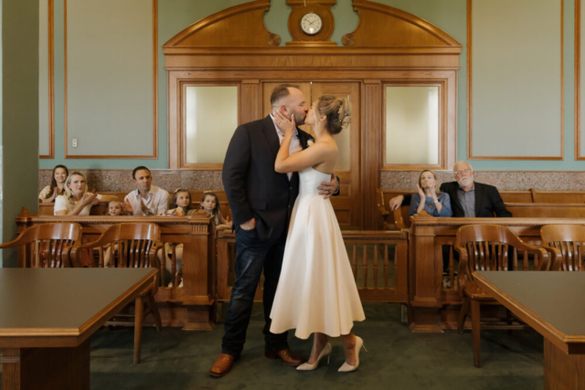 A young bride and groom at the Tarrant County Courthouse on their intimate elopement wedding day in Fort Worth, Texas.