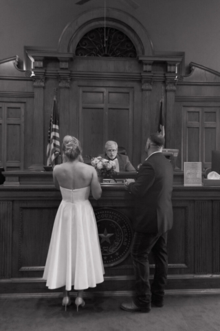 A young bride and groom at the Tarrant County Courthouse on their intimate elopement wedding day in Fort Worth, Texas.