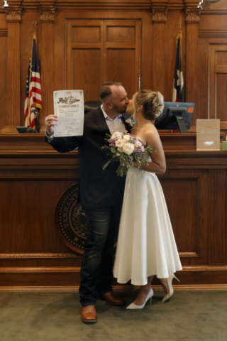 A young bride and groom at the Tarrant County Courthouse on their intimate elopement wedding day in Fort Worth, Texas.