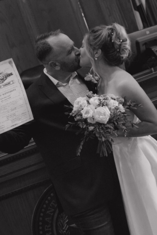 A young bride and groom at the Tarrant County Courthouse on their intimate elopement wedding day in Fort Worth, Texas.