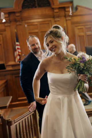 A young bride and groom at the Tarrant County Courthouse on their intimate elopement wedding day in Fort Worth, Texas.