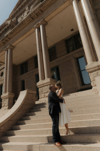 A young bride and groom at the Tarrant County Courthouse on their intimate elopement wedding day in Fort Worth, Texas.