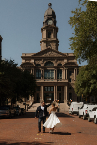 A young bride and groom at the Tarrant County Courthouse on their intimate elopement wedding day in Fort Worth, Texas.