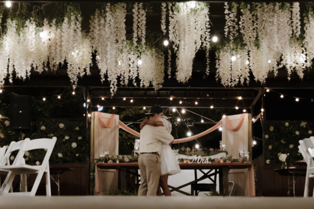 A young bride and groom at their cinematic, intimate outdoor wedding ceremony have candid photos taken of their wedding decor and their guests in the DFW area by Texas wedding photographer Hannah Lylene Photography.