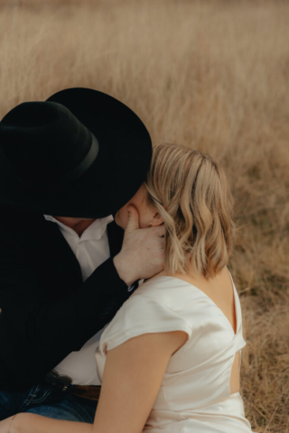 A couple in neutral attire run in an open field take their cinematic and documentary style engagement photos by Hannah Lylene Photography.