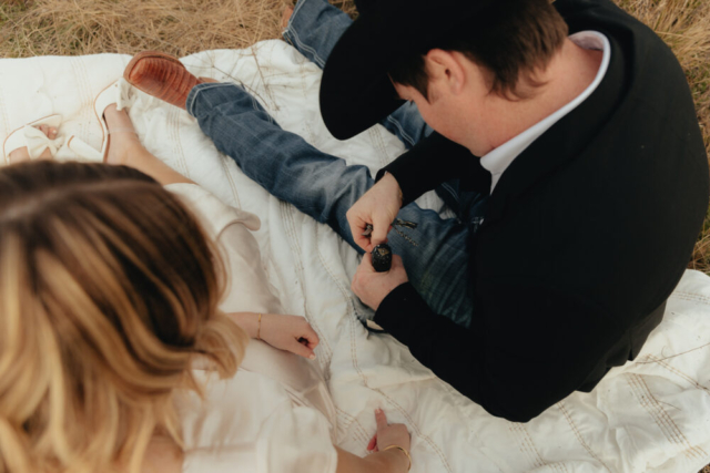 A couple in neutral attire run in an open field take their cinematic and documentary style engagement photos by Hannah Lylene Photography.