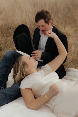 A couple in neutral attire run in an open field take their cinematic and documentary style engagement photos by Hannah Lylene Photography.