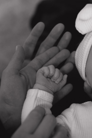 A young couple holds their newborn baby in their nursery to take intimate family photos in Dallas, Texas.