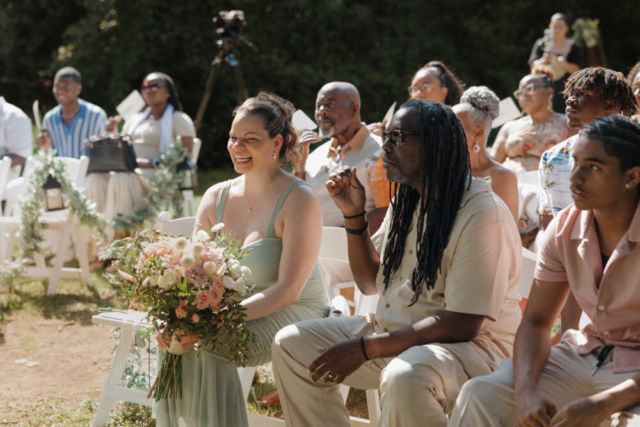 A young bride and groom at their cinematic, intimate outdoor wedding ceremony have candid photos taken of their wedding decor and their guests in the DFW area by Texas wedding photographer Hannah Lylene Photography.