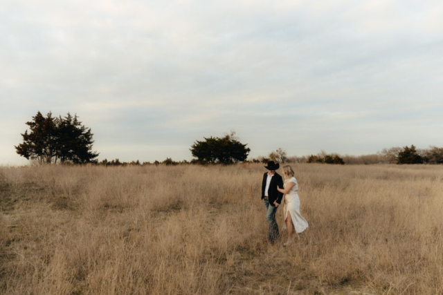 A couple in neutral attire run in an open field take their cinematic and documentary style engagement photos by Hannah Lylene Photography.