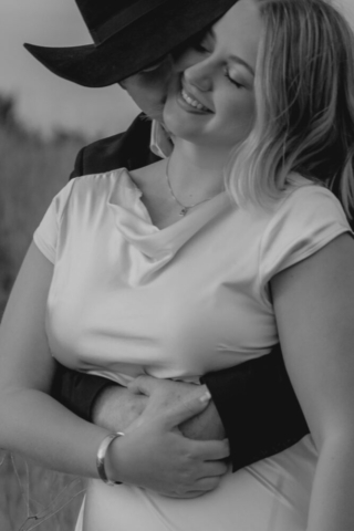 A couple in neutral attire run in an open field take their cinematic and documentary style engagement photos by Hannah Lylene Photography.