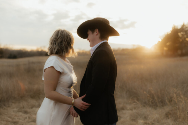 A couple in neutral attire run in an open field take their cinematic and documentary style engagement photos by Hannah Lylene Photography.