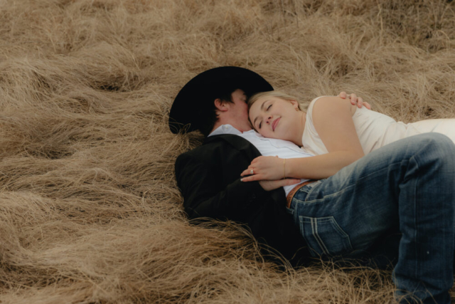 A couple in neutral attire run in an open field take their cinematic and documentary style engagement photos by Hannah Lylene Photography.