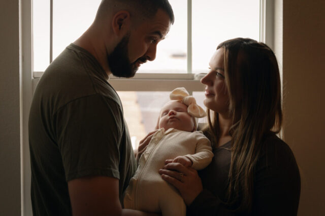 Hannah-Lylene-Dallas-Fort-Worth-Photographer-5243 A young couple holds their newborn baby in their nursery to take intimate family photos in Dallas, Texas.