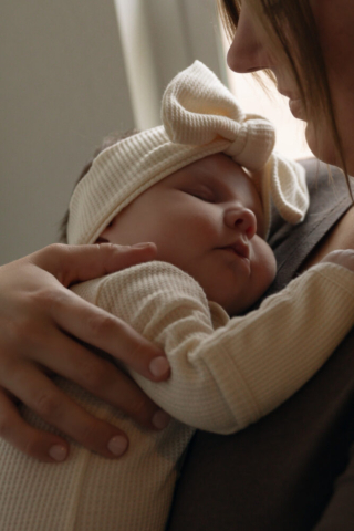 A young couple holds their newborn baby in their nursery to take intimate family photos in Dallas, Texas.