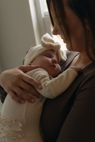 A young couple holds their newborn baby in their nursery to take intimate family photos in Dallas, Texas.