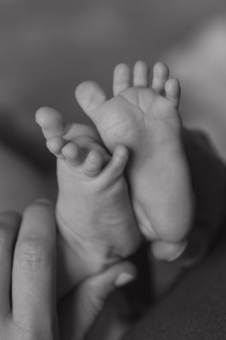 A young couple holds their newborn baby in their nursery to take intimate family photos in Dallas, Texas.