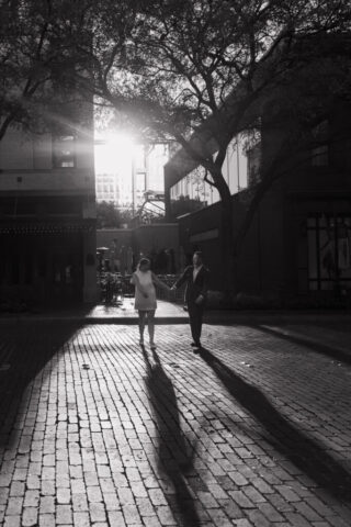 A couple in editorial neutral attire take their documentary style wedding engagement photos in Downtown Fort Worth.