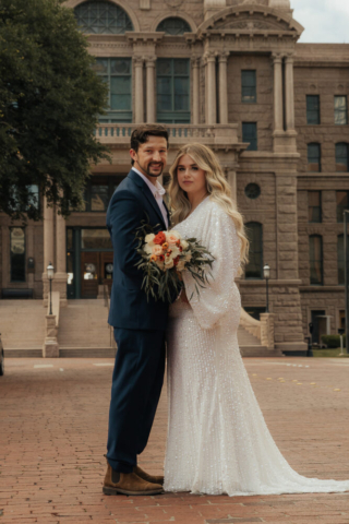 A young bride and groom at the Tarrant County Courthouse and Fort Worth Stockyards on their intimate elopement wedding day in Fort Worth, Texas.