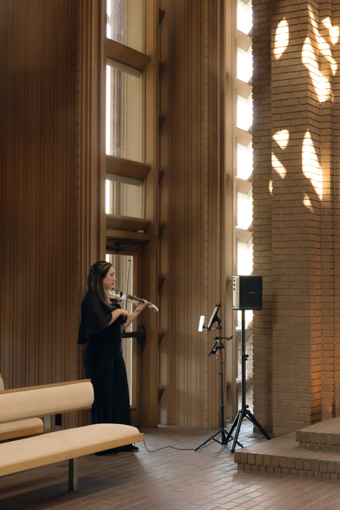 vioinist-wedding-ceremony A young couple gets married at the Marty Leonard Chapel in Fort Worth, Texas by a documentary wedding photographer ( Hannah Lylene Photography)