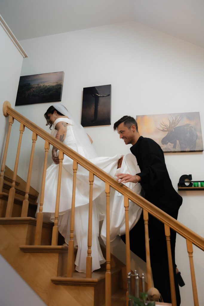 Bride walking upstairs with groom assisting her