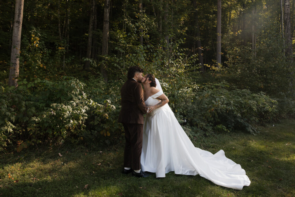 Bride and groom embrace in forest setting
