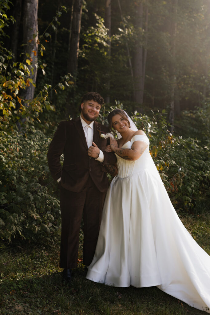 Couple in wedding attire posing in a forest