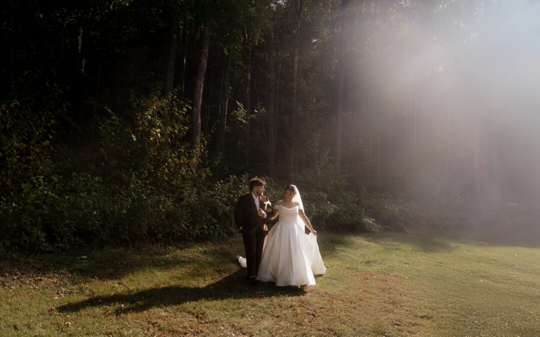 Bride and groom walking in a sunlit forest clearing