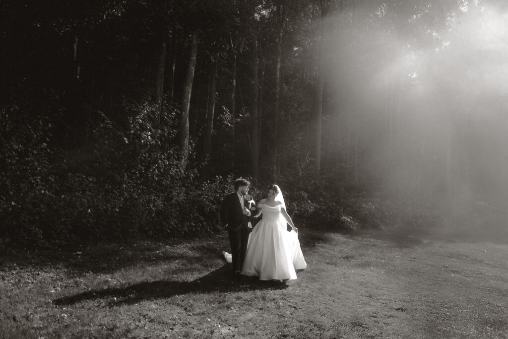 Bride and groom walking in a sunlit forest