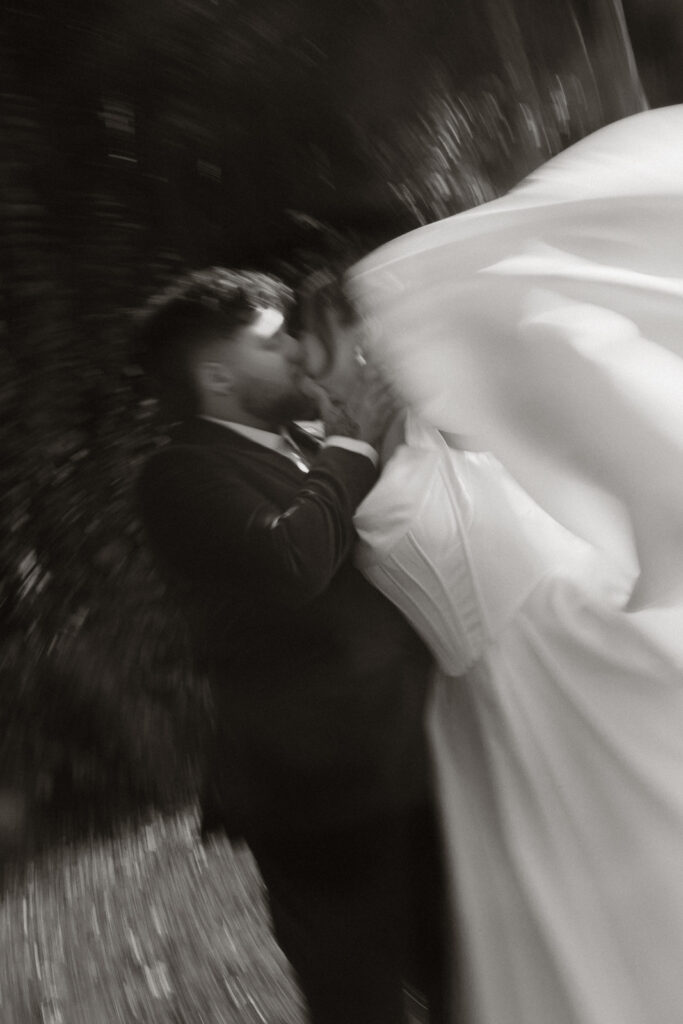 Artistic black and white photo of a couple kissing in motion blur