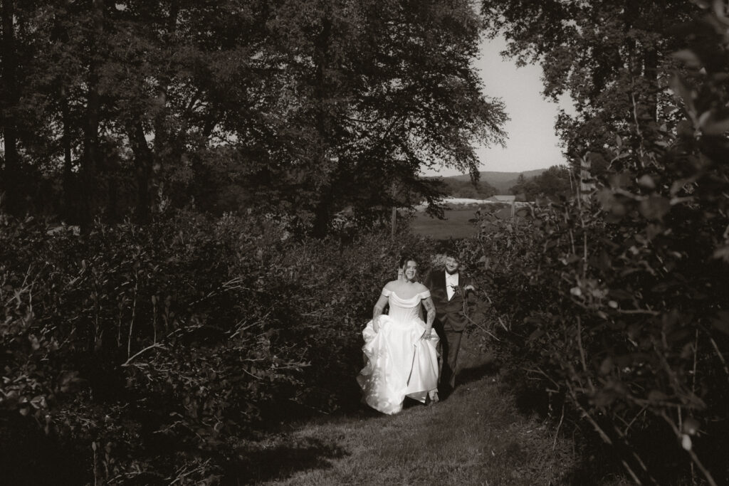 Bride and groom walking down a wooded path