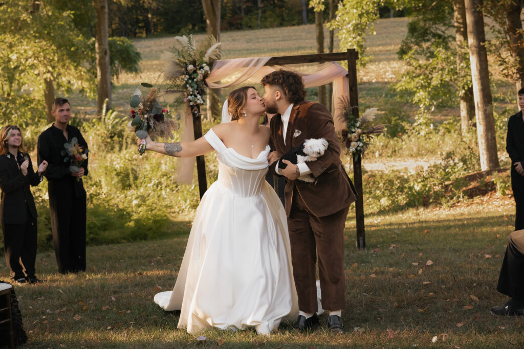 Bride and groom kissing at outdoor wedding ceremony