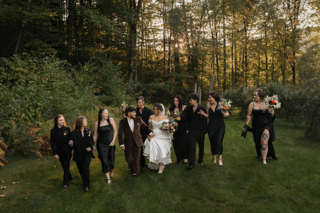 Wedding party walking through a forest clearing