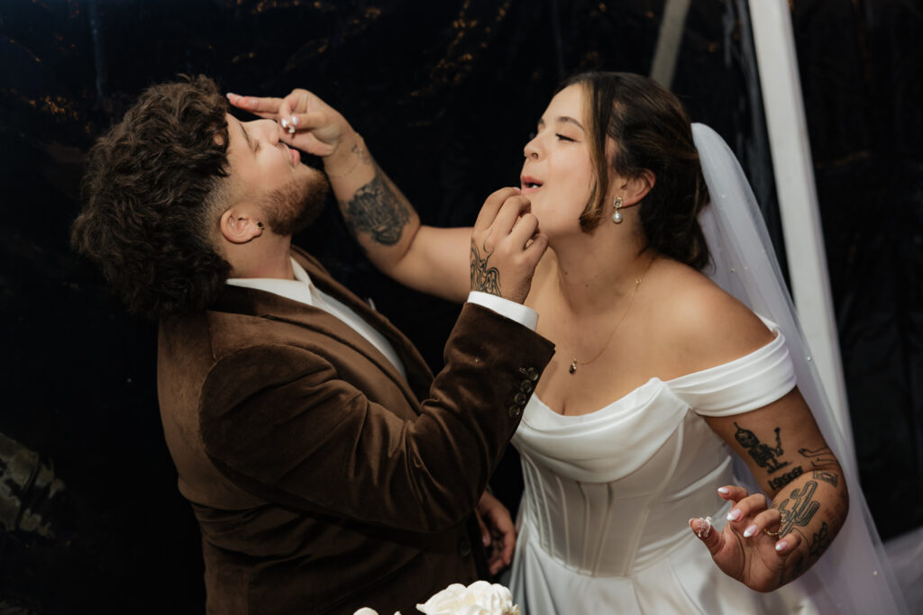 Couple feeding each other wedding cake