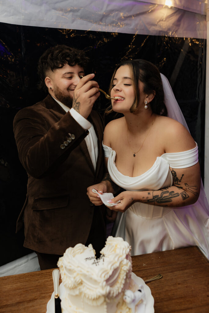 Bride and groom feeding each other wedding cake