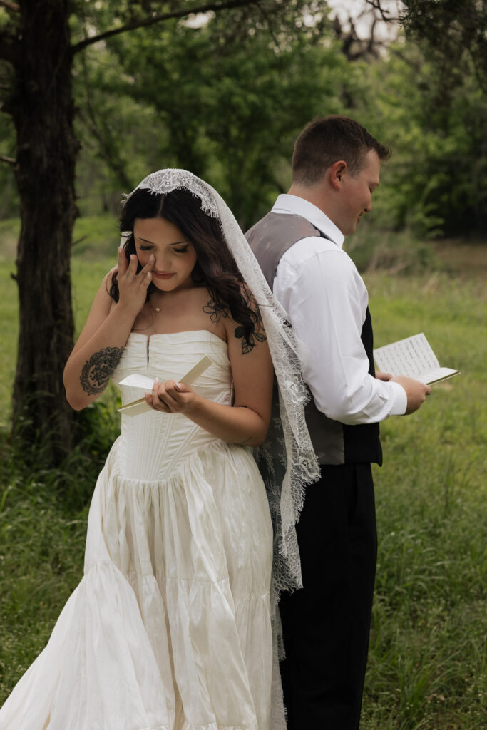 Bride and groom reading vows outdoors