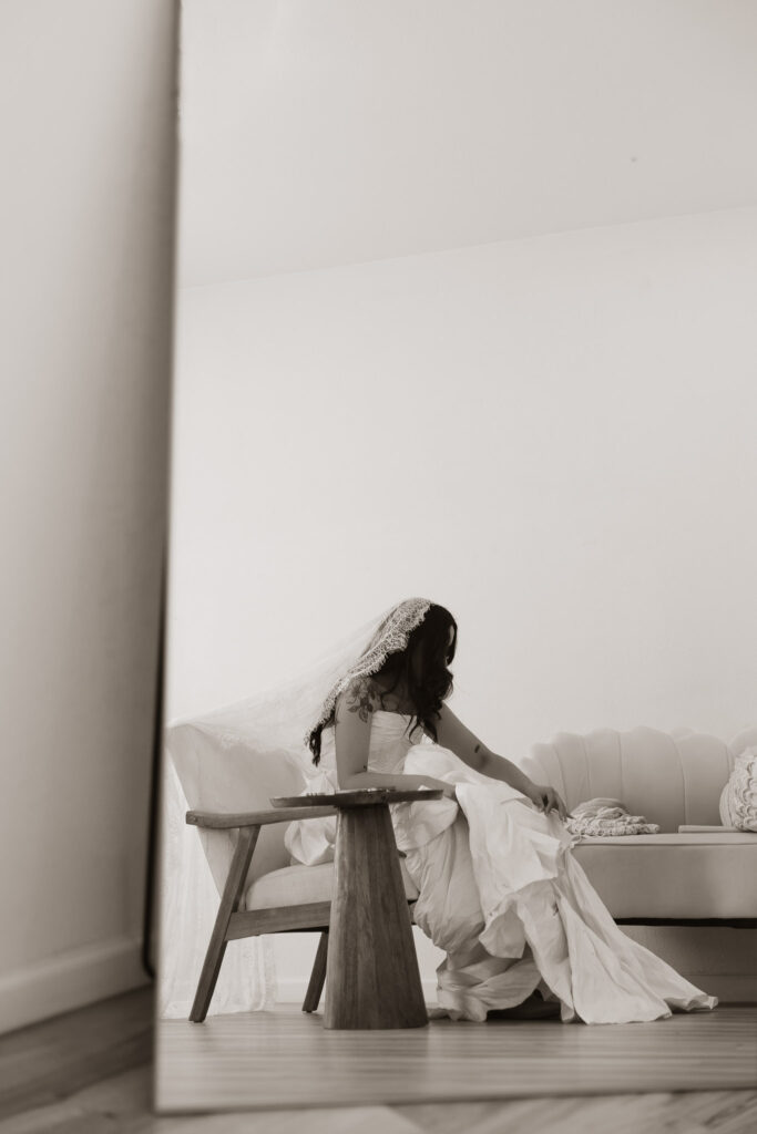Bride sitting in chair wearing a wedding dress and veil