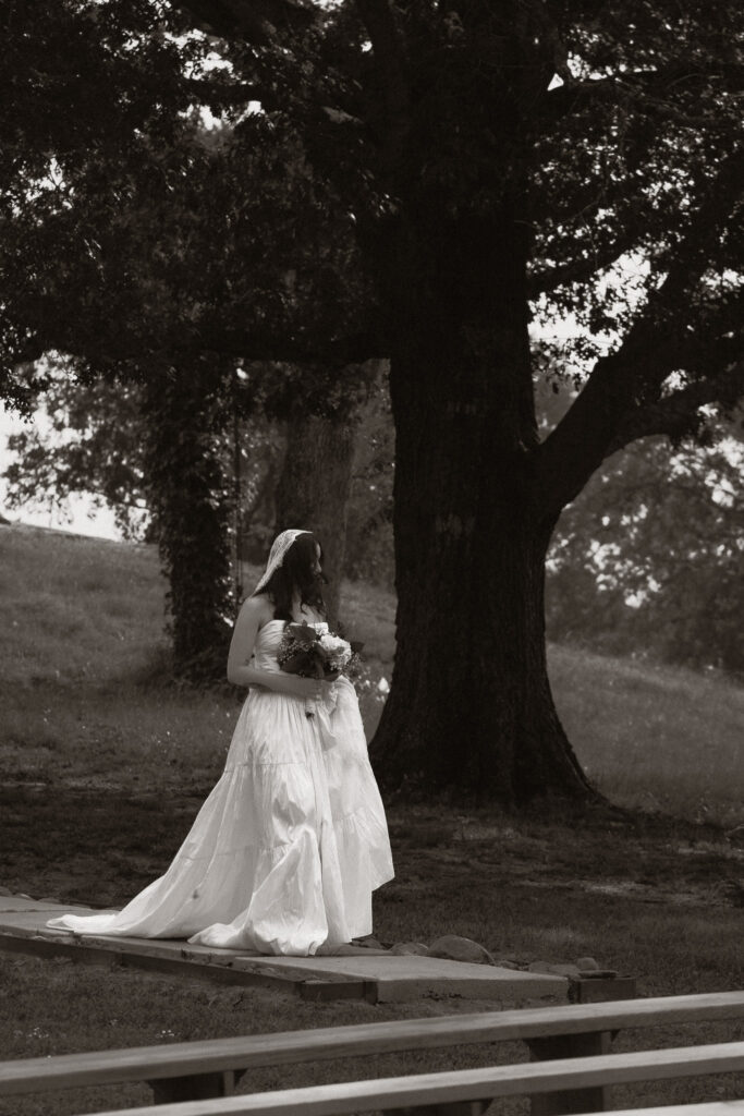 Bride walking outdoors under a large tree