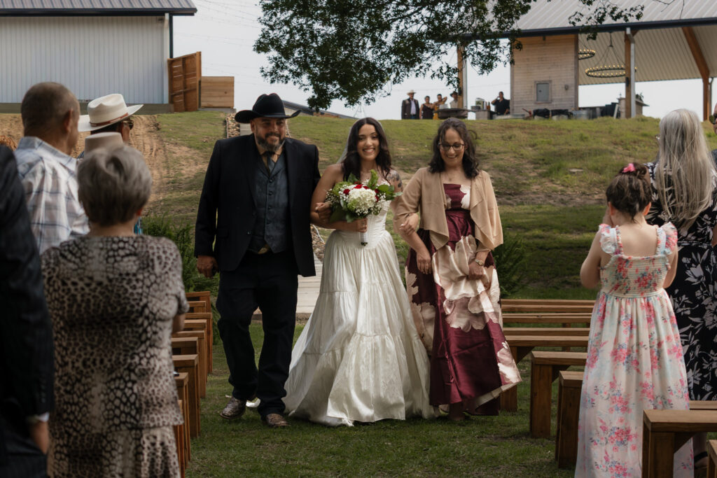 Bride walking down the aisle with parents