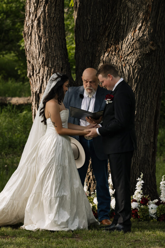 Bride and groom holding hands during outdoor wedding ceremony