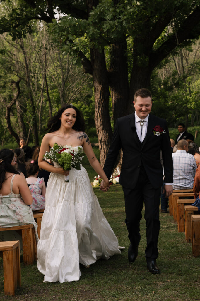 Bride and groom walking down the aisle outdoors