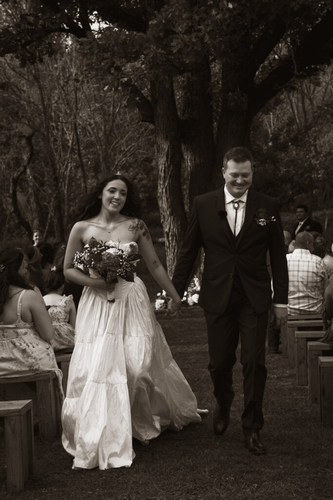Bride and groom walking hand in hand outdoors