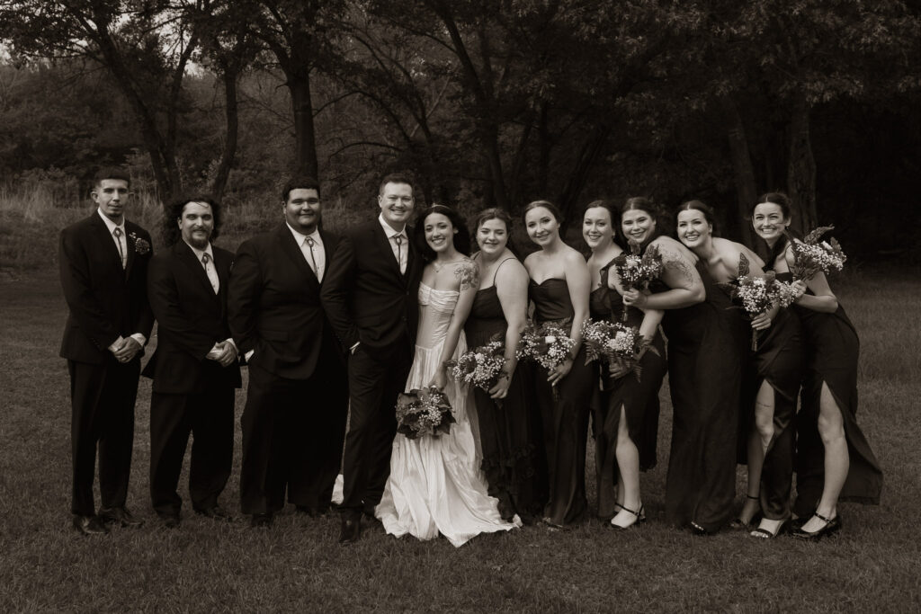 Wedding party posing together outdoors in formal attire